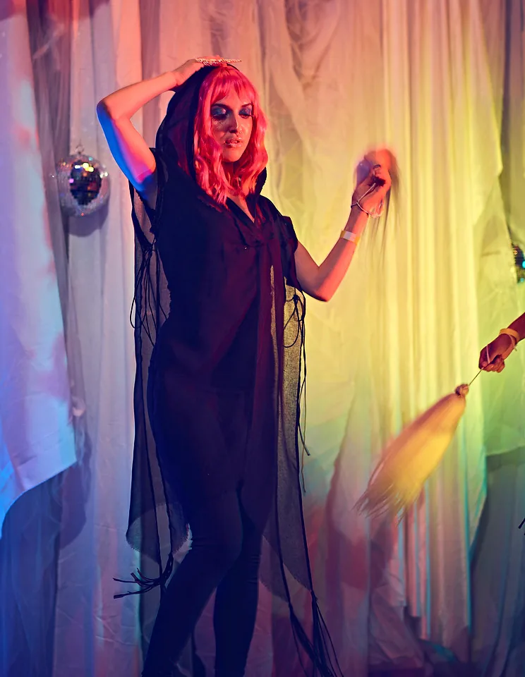 Black voile tunic against colored drapes