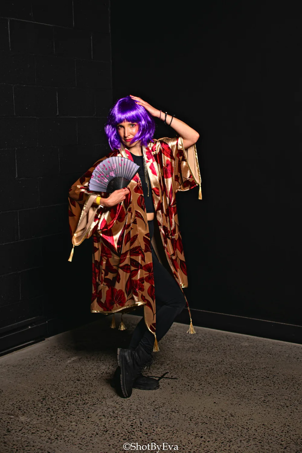 Burgundy robe with gold patterns, fan in hand